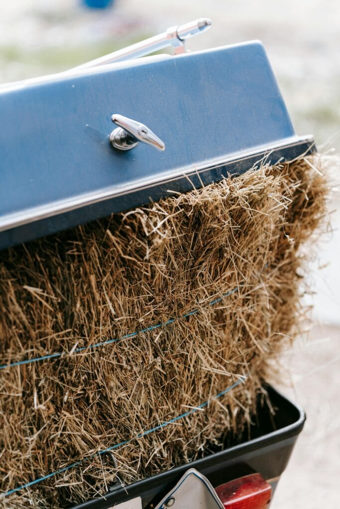 A detailed close-up of hay bales inside a blue metallic trailer, capturing texture and color.