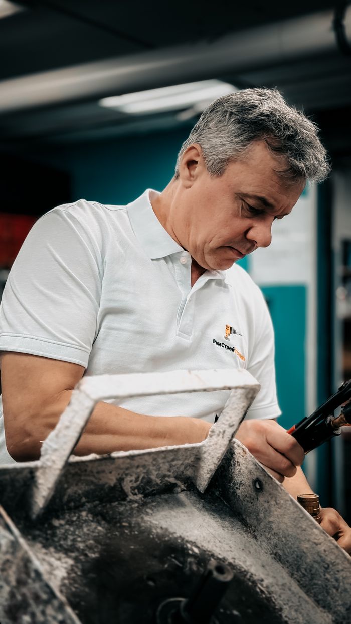 Focused male technician working on machinery in an industrial setting.