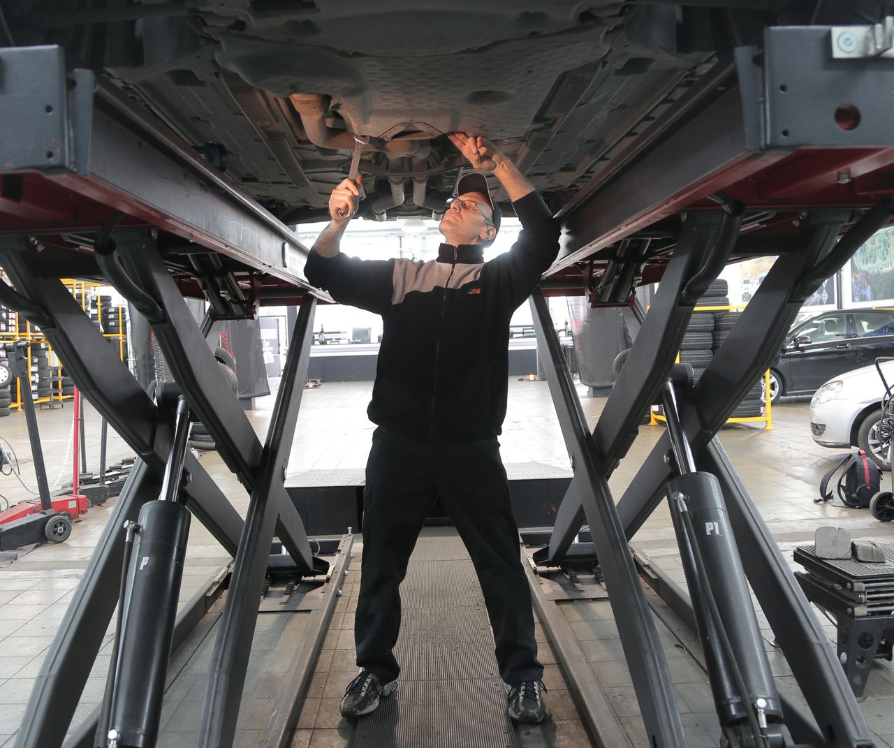 who-we-are Mechanic inspecting and repairing a vehicle in a professional auto garage.